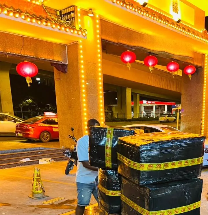 Colis emballés d'un départ express chargés sur un chariot devant l'entrepôt, de nuit