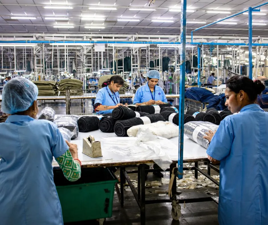 Des ouvriers emballant des rouleaux de tissu dans une usine en Chine